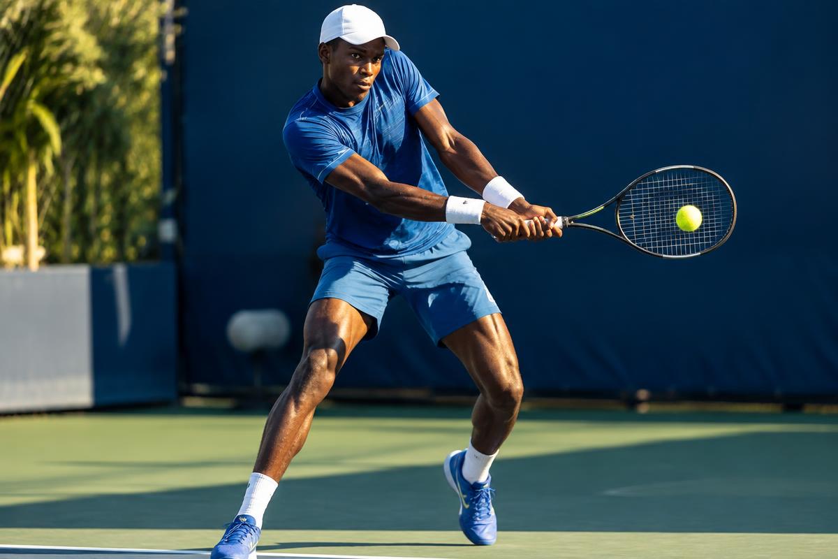 Black African tennis player competing under floodlights